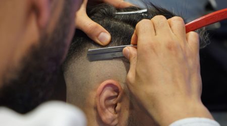 A man with a textured crop haircut featuring choppy layers on top and faded sides, styled in a bright bathroom.