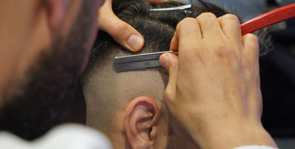 A man with a textured crop haircut featuring choppy layers on top and faded sides, styled in a bright bathroom.